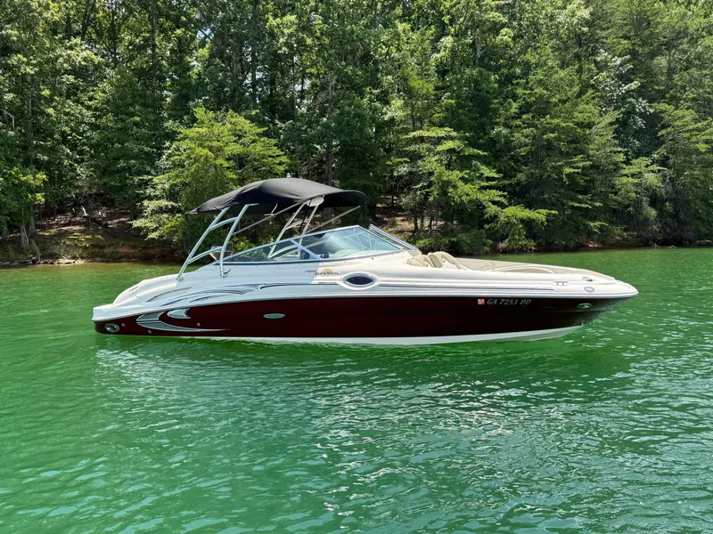Slide: The Image of 2006 Sea Ray 270 Sundeck boat on a serene lake with lush green trees. - 14