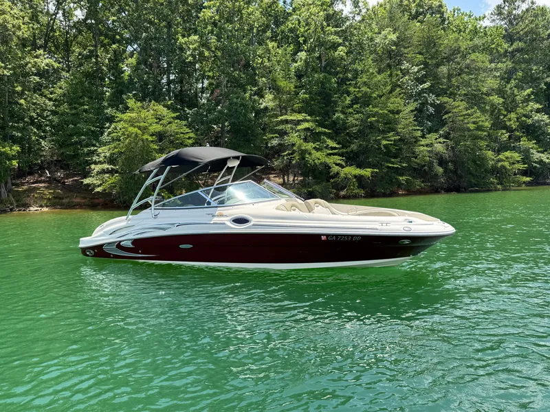 Slide: The Image of 2006 Sea Ray 270 Sundeck boat on a serene lake with lush green trees. - 15