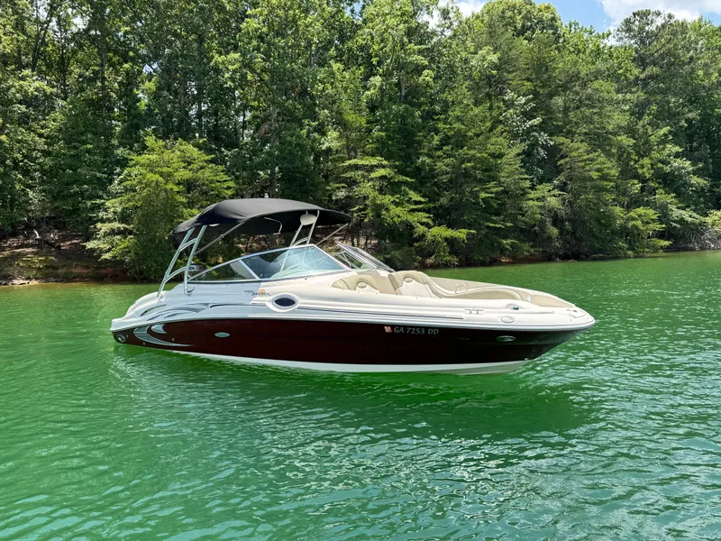 Slide: The Image of 2006 Sea Ray 270 Sundeck boat on a serene lake with lush green trees. - 16