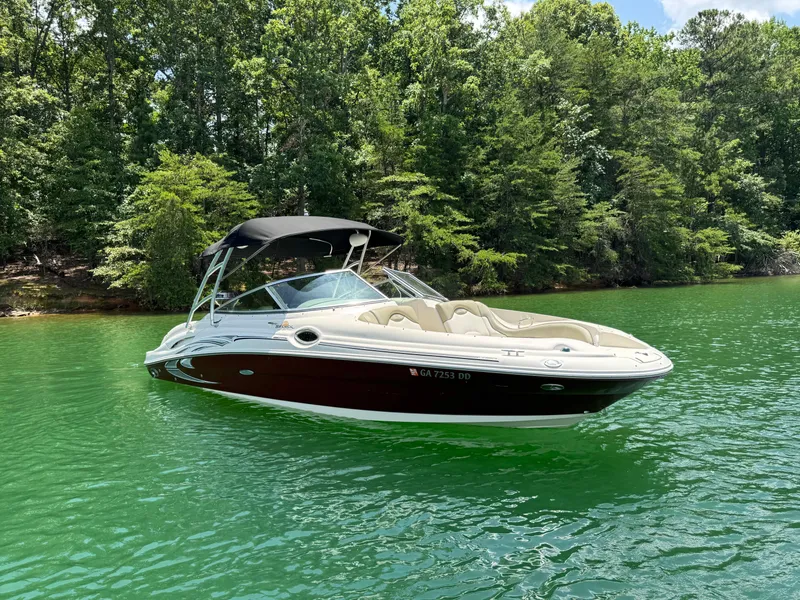 Slide: The Image of 2006 Sea Ray 270 Sundeck boat on a serene lake with lush green trees. - 17