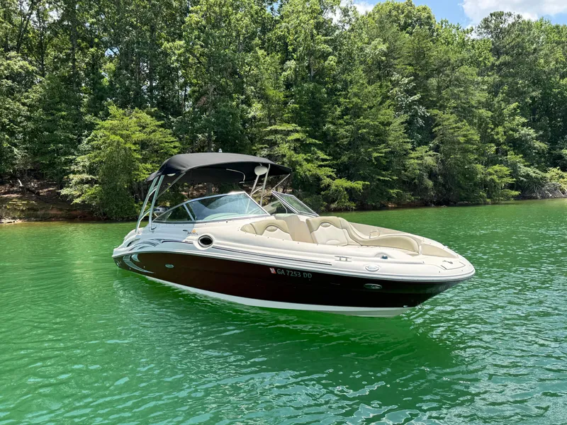 Slide: The Image of 2006 Sea Ray 270 Sundeck boat on a serene lake with lush green trees. - 18