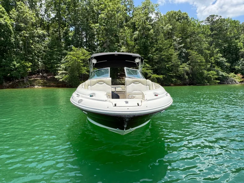 Slide: The Image of 2006 Sea Ray 270 Sundeck boat on vibrant green lake, surrounded by lush trees. - 20