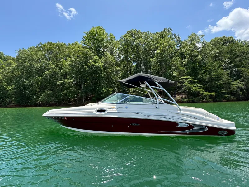Slide: The Image of 2006 Sea Ray 270 Sundeck boat on a lake with lush green trees. - 21
