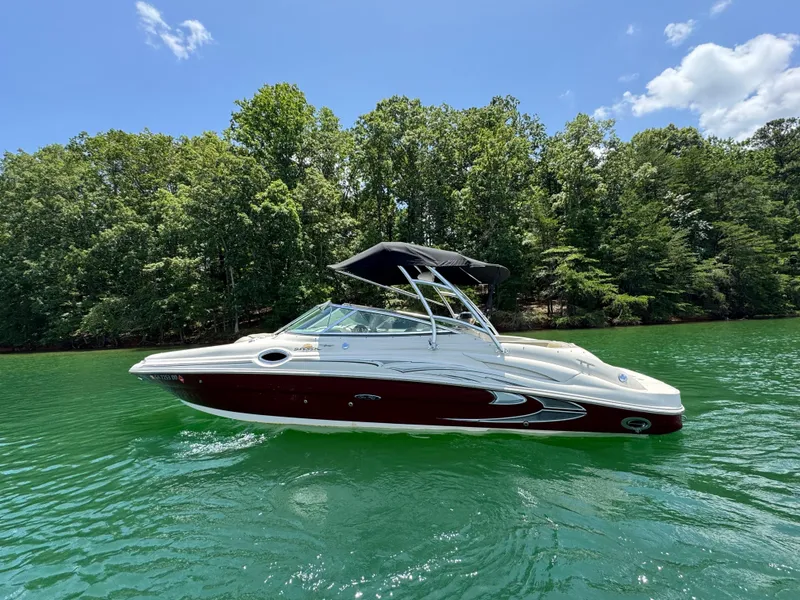 Slide: The Image of 2006 Sea Ray 270 Sundeck boat on a serene lake with lush green trees. - 22