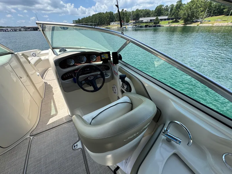 Slide: The Image of 2006 Sea Ray 270 Sundeck boat interior with steering wheel, dashboard, and lake view. - 24