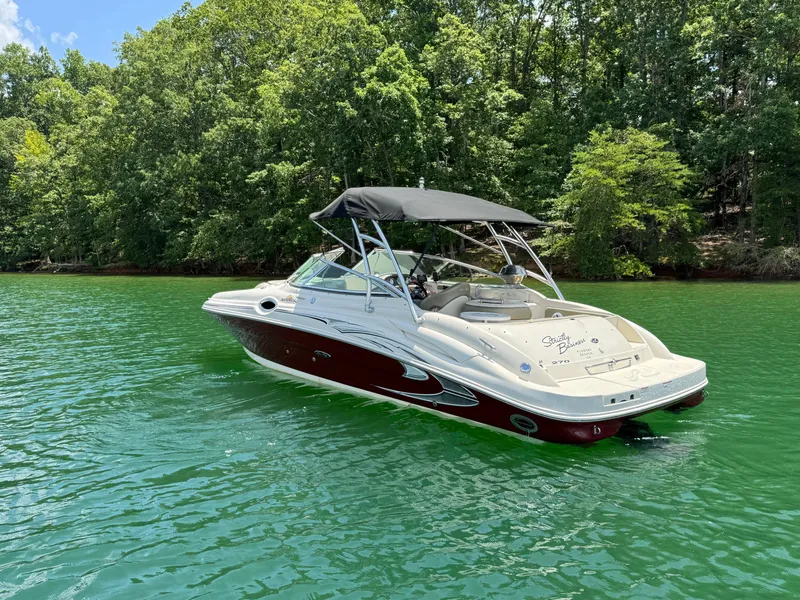 Slide: The Image of 2006 Sea Ray 270 Sundeck boat on a serene lake with lush green trees. - 3
