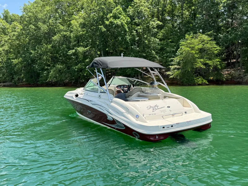 Slide: The Image of 2006 Sea Ray 270 Sundeck boat on a serene lake with lush green trees. - 4