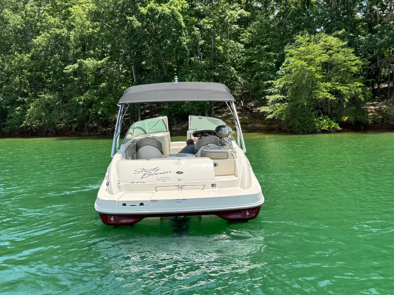 Slide: The Image of 2006 Sea Ray 270 Sundeck boat on a serene lake with lush green trees. - 5