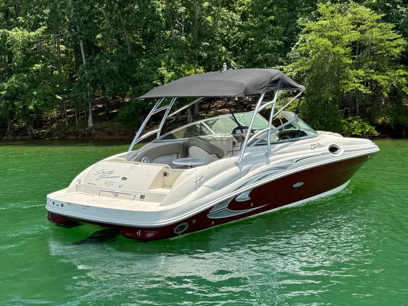 Slide: The Image of 2006 Sea Ray 270 Sundeck boat on a serene lake with lush green trees. - 8