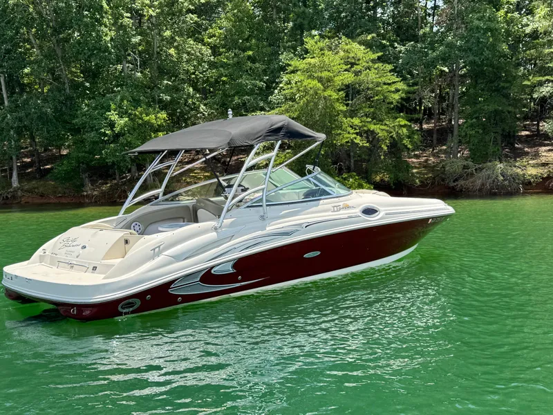 Slide: The Image of 2006 Sea Ray 270 Sundeck boat on a serene lake with lush green trees. - 9