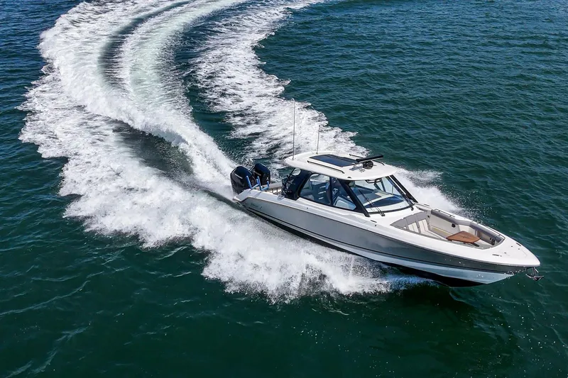 Slide: The Image of 2024 Boston Whaler 380 Realm cruising on open water, creating dynamic wake patterns. - 24