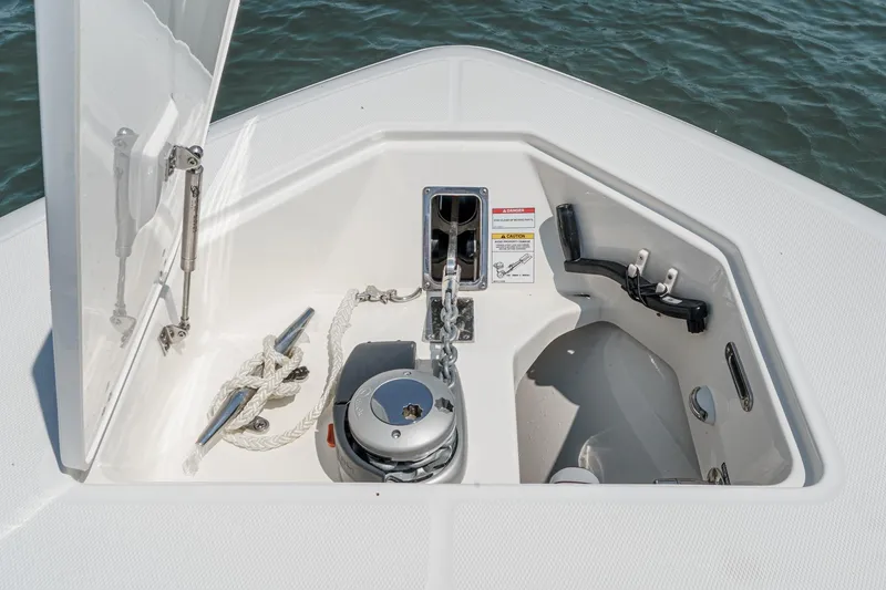 Slide: The Image of 2024 Boston Whaler 380 Realm anchor compartment with rope and cleat, open hatch view. - 36
