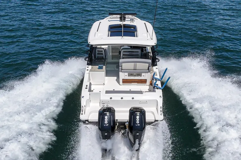 Slide: The Image of 2024 Boston Whaler 380 Realm cruising on open water, rear view. - 37