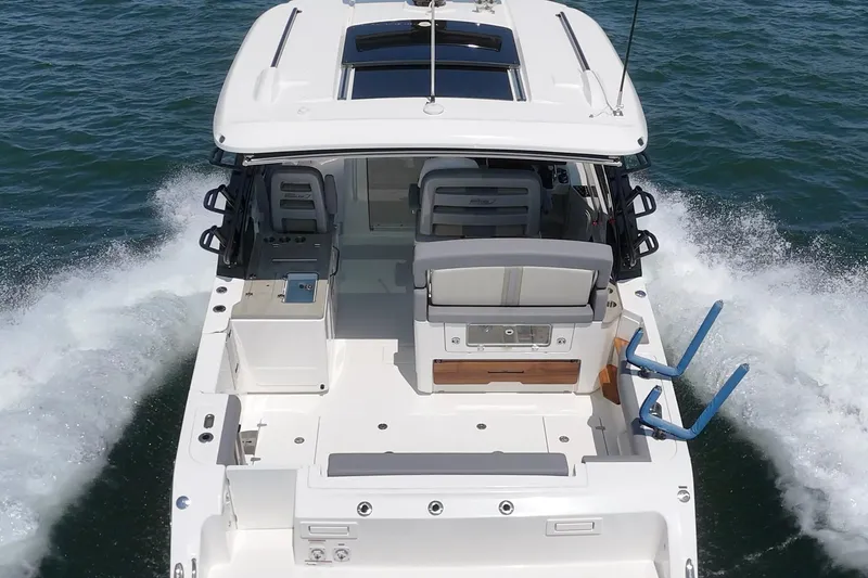 Slide: The Image of 2024 Boston Whaler 380 Realm cruising on open water, rear view. - 39