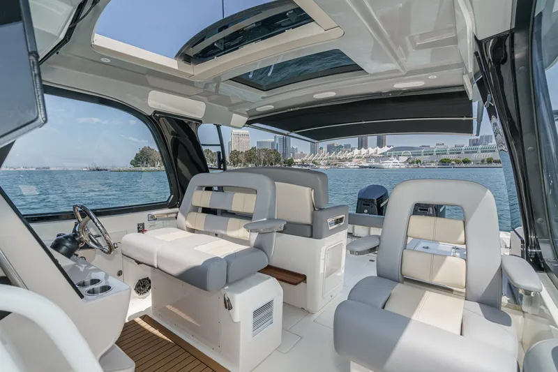 Slide: The Image of 2024 Boston Whaler 380 Realm interior with luxurious seating and panoramic water views. - 58