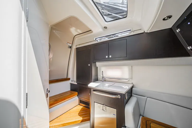 Slide: The Image of 2024 Boston Whaler 380 Realm interior with modern kitchenette and seating area. - 72