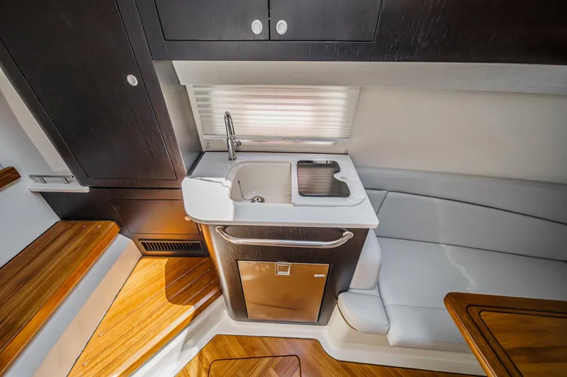 Slide: The Image of 2024 Boston Whaler 380 Realm interior with kitchenette and seating area. - 73