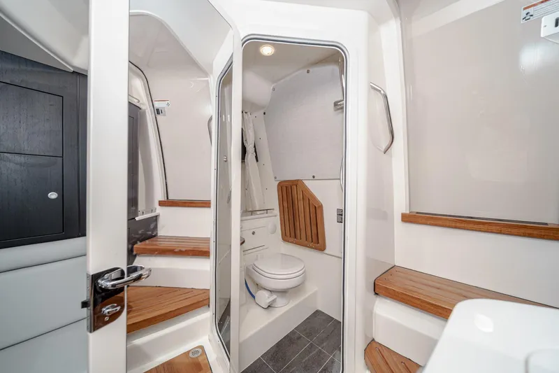 Slide: The Image of 2024 Boston Whaler 380 Realm interior bathroom with modern design and wooden accents. - 75
