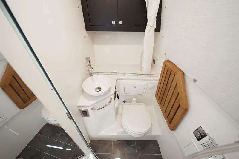 Slide: The Image of 2024 Boston Whaler 380 Realm bathroom with modern fixtures and wooden accents. - 76