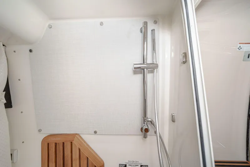 Slide: The Image of 2024 Boston Whaler 380 Realm interior shower with modern fixtures and wooden accents. - 77