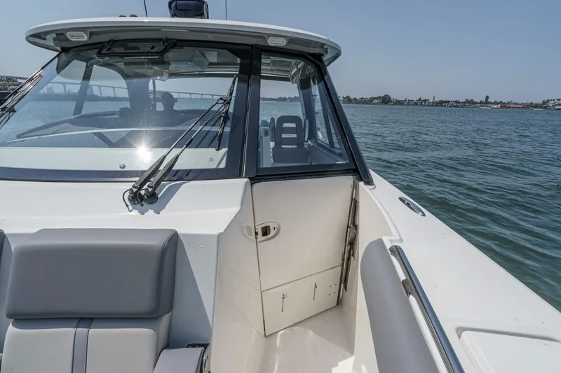 Slide: The Image of 2024 Boston Whaler 380 Realm boat interior with open cabin door on water. - 82
