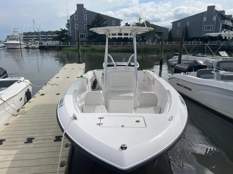 Slide: The Image of 2023 Aquasport 22CC boat docked at marina, featuring sleek design and spacious seating. - 12