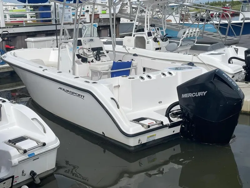 Slide: The Image of 2023 Aquasport 22CC boat with Mercury engine docked at marina. - 13