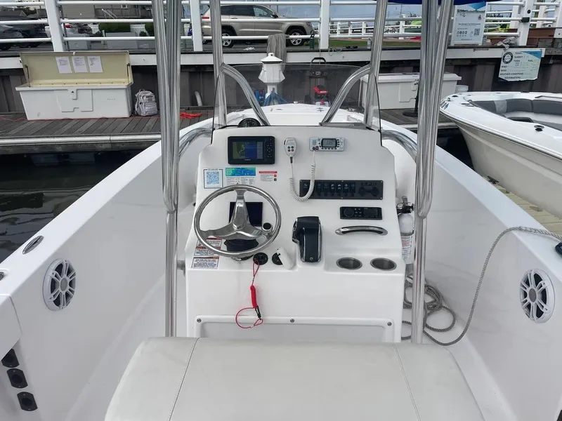 Slide: The Image of 2023 Aquasport 22CC boat console with steering wheel and navigation equipment at dock. - 15