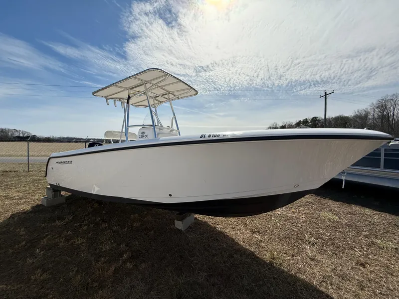 Slide: The Image of 2023 Aquasport 22CC boat on display under a partly cloudy sky. - 3