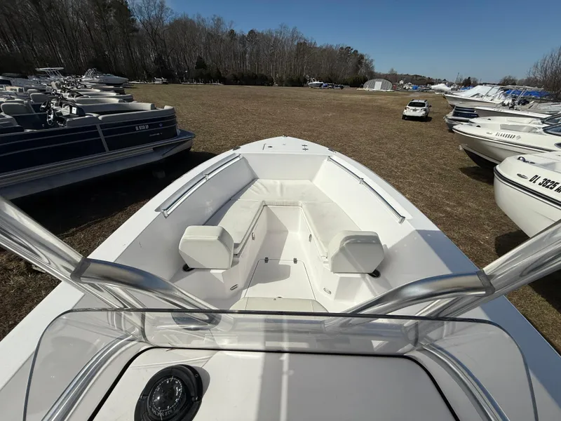 Slide: The Image of 2023 Aquasport 22CC boat, white interior, parked outdoors among other boats. - 7