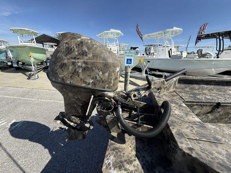Slide: The Image of Camouflage-patterned Excel Viper F4 1751 boat with aluminum trailer, parked near other boats. - 6