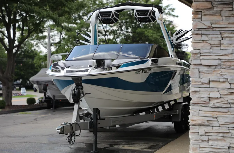 Slide: The Image of 2021 Centurion Ri245 boat on trailer, parked outdoors near stone wall. - 15