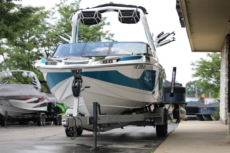 Slide: The Image of 2021 Centurion Ri245 boat on trailer, parked outdoors near trees and buildings. - 7
