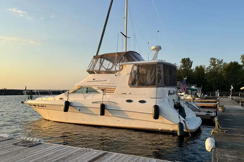 The Image of 1998 Sea Ray 420 Aft Cabin yacht docked at sunset, calm waters, clear sky. - 0
