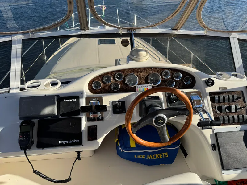 Slide: The Image of 1998 Sea Ray 420 Aft Cabin helm with wooden steering wheel and navigation instruments. - 12
