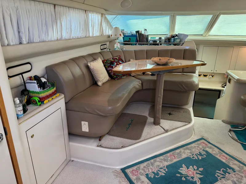 Slide: The Image of Interior of 1998 Sea Ray 420 Aft Cabin with cozy seating and table. - 19