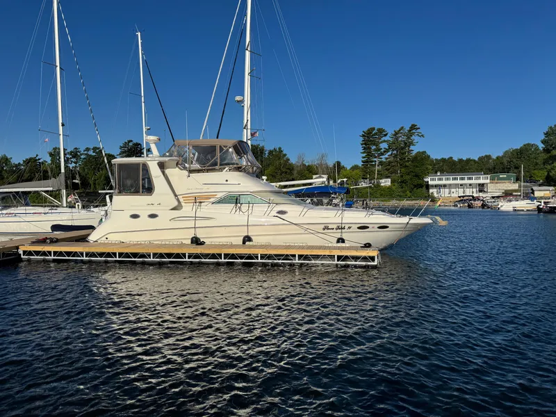 Slide: The Image of 1998 Sea Ray 420 Aft Cabin yacht docked at marina under clear blue sky. - 2