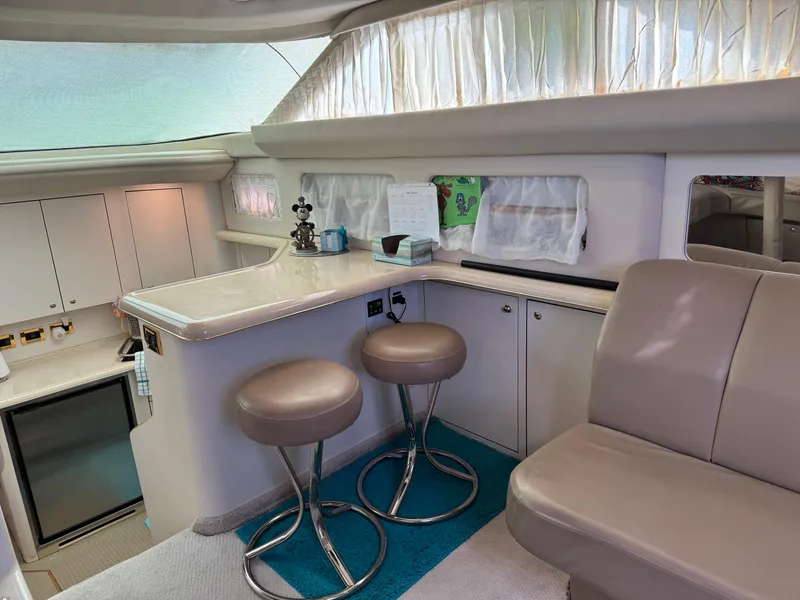 Slide: The Image of Luxurious interior of a 1998 Sea Ray 420 Aft Cabin yacht with bar stools and seating. - 20