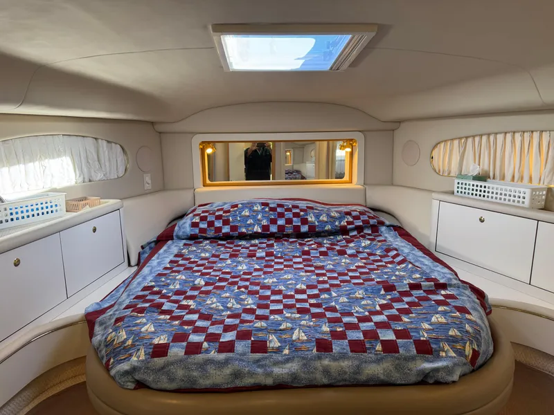 Slide: The Image of Luxurious 1998 Sea Ray 420 Aft Cabin bedroom with quilted bedspread and ample storage. - 24
