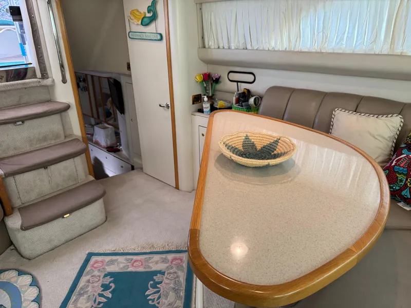 Slide: The Image of Interior of 1998 Sea Ray 420 Aft Cabin with table, seating, and stairs. - 28