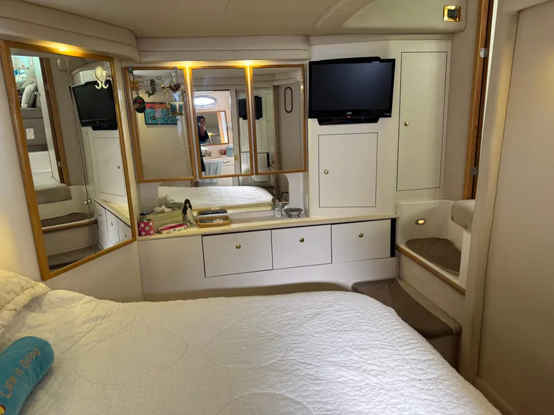 Slide: The Image of Luxurious 1998 Sea Ray 420 Aft Cabin bedroom with mirrors and TV. - 32