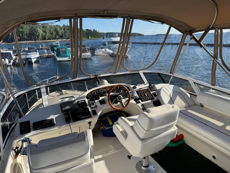 Slide: The Image of 1998 Sea Ray 420 Aft Cabin yacht interior with helm, docked at marina. - 7