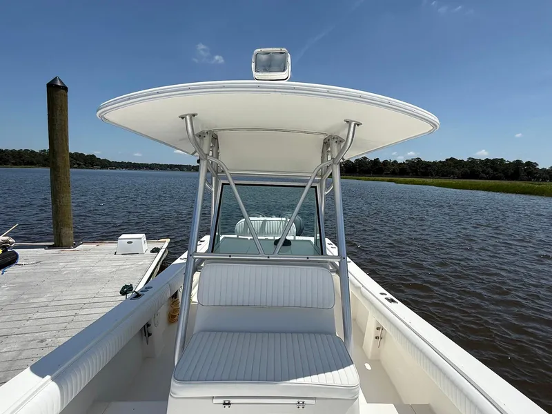 Slide: The Image of 2006 Regulator 26 Forward Seating boat docked on a sunny day by the water. - 15