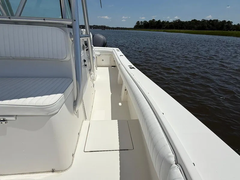 Slide: The Image of 2006 Regulator 26 Forward Seating boat on calm water, featuring white seating and sleek design. - 16