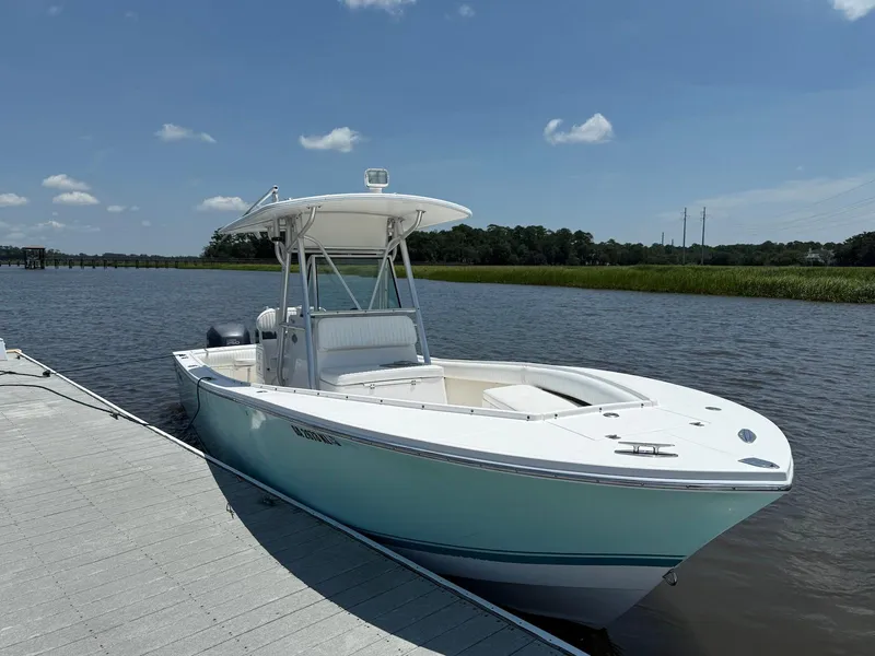 Slide: The Image of 2006 Regulator 26 Forward Seating boat docked on a sunny day. - 2