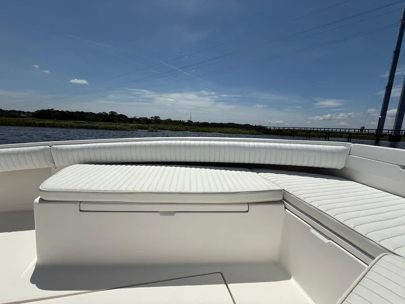 Slide: The Image of 2006 Regulator 26 Forward Seating boat with white cushioned seats on a sunny day. - 20