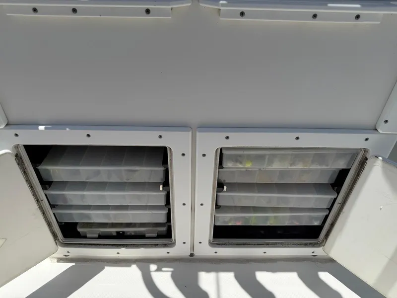 Slide: The Image of Storage compartments on a 2006 Regulator 26 Forward Seating boat, featuring organized tackle boxes. - 27