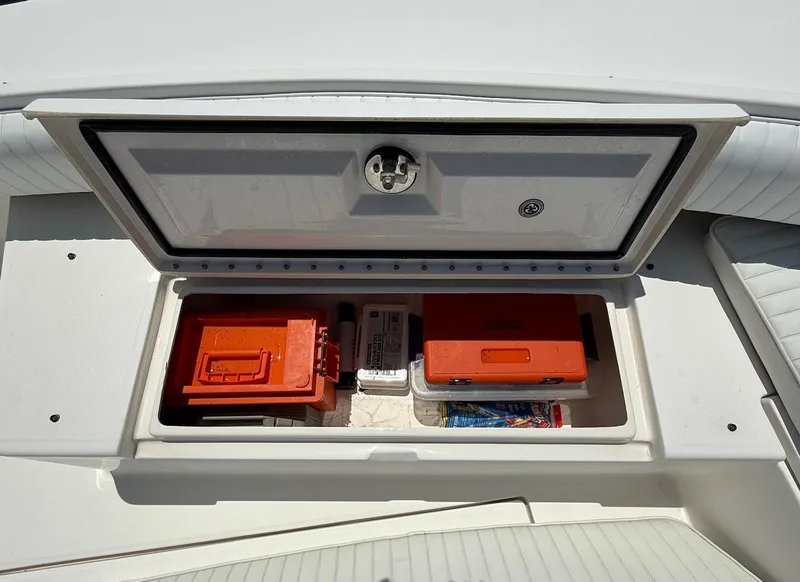 Slide: The Image of Storage compartment on a 2006 Regulator 26 Forward Seating boat, containing safety equipment. - 38