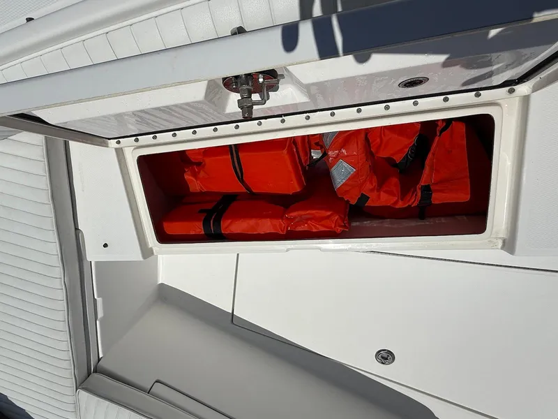 Slide: The Image of Storage compartment with orange life jackets on a 2006 Regulator 26 Forward Seating boat. - 39