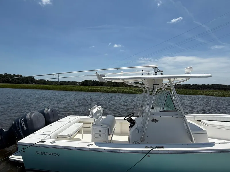 Slide: The Image of 2006 Regulator 26 Forward Seating boat on calm water under clear blue sky. - 5